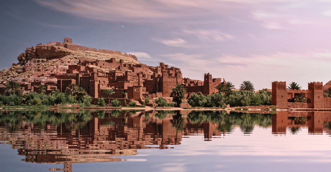 Oasis in the Sahara Desert surrounded by palm trees and golden dunes