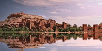 Oasis in the Sahara Desert surrounded by palm trees and golden dunes