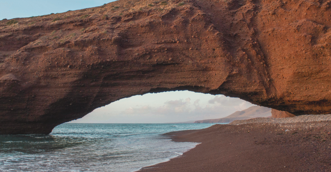 Beach with golden dunes in Morocco, perfect road trip stop with a rental car.