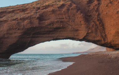 Beach with golden dunes in Morocco, perfect road trip stop with a rental car.
