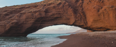 Beach with golden dunes in Morocco, perfect road trip stop with a rental car.